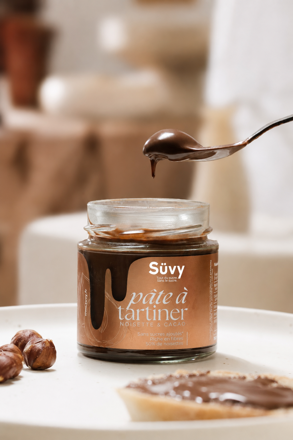 A jar of Süvy hazelnut and cocoa spread with a spoonful of spread